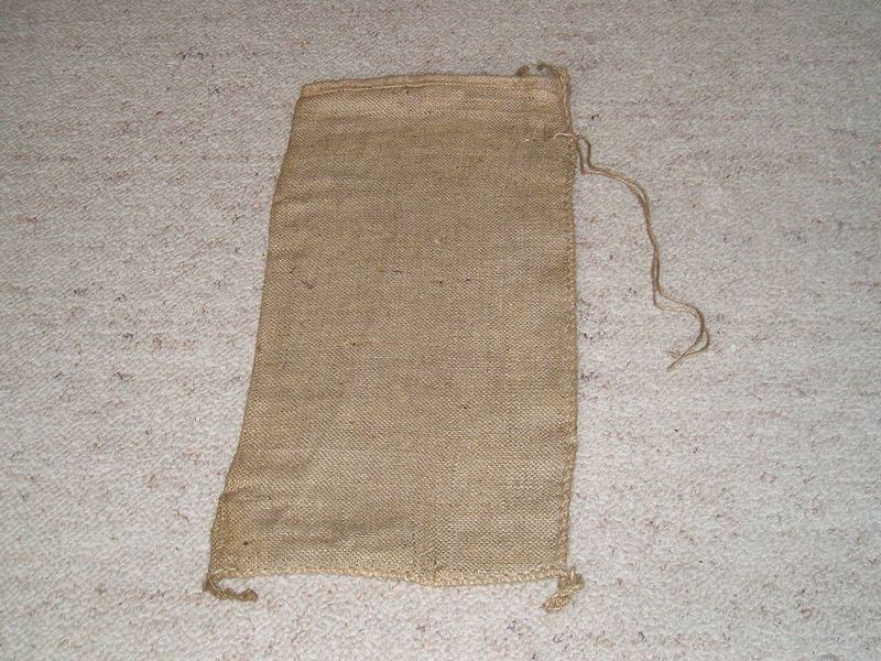 Jutesandsack 30 × 60 cm aus Naturfaser, flach liegend, mit außen an der Naht angenähtem Bindeband