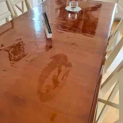 Holztisch abgedeckt mit transparenter Folie.