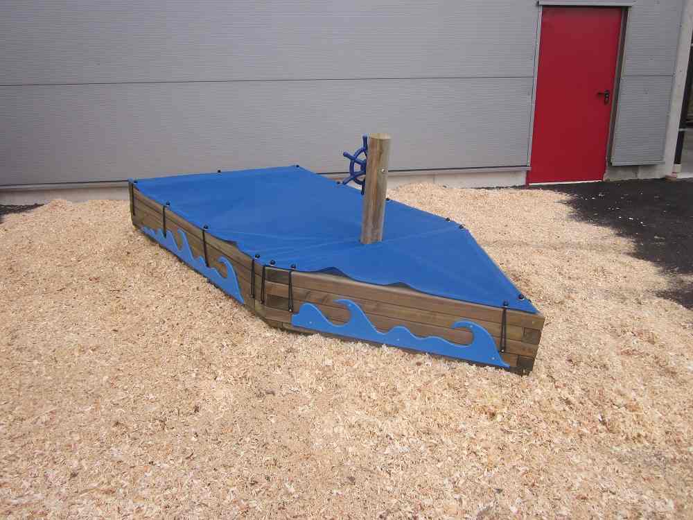 Bootförmiger Sandkasten mit blauen Wellen an der Seite und passender, blauer Sandakstenabdeckung